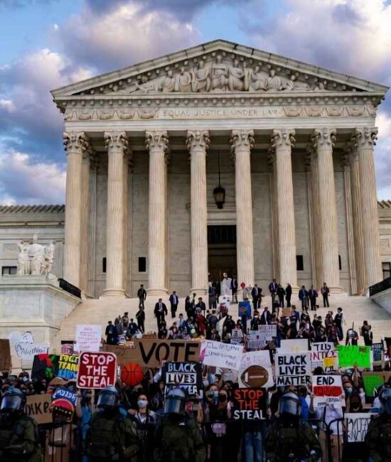 Supreme-Court-Trans-Athletes-US-Supreme-Court-building-with-protesters-holding-signs-about-transgender-athletes-and-womens-sports-rights-during-landmark-2026-case-hearing